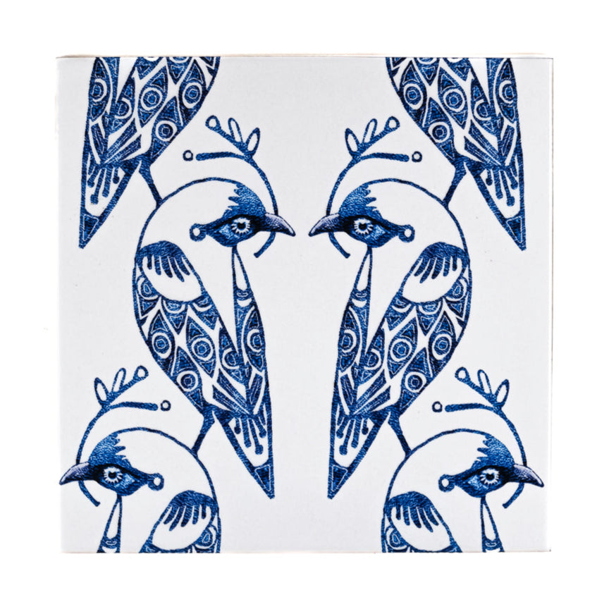Decorative tile with blue and white bird design on a white background