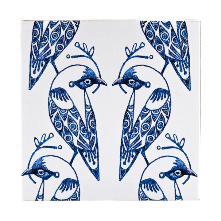 Decorative tile with blue and white bird design on a white background