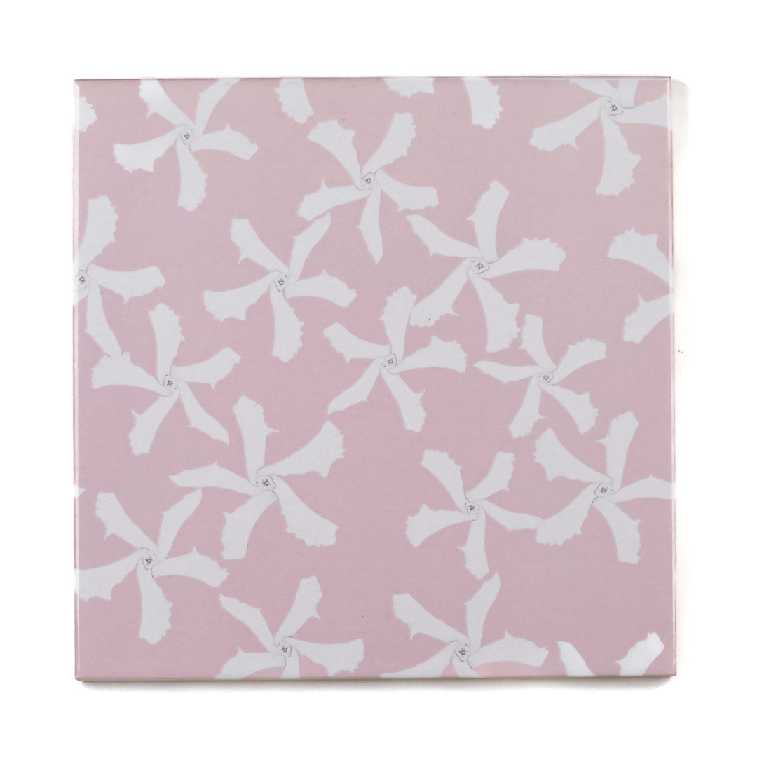 Pink ceramic tile with white floral pattern on a pink background