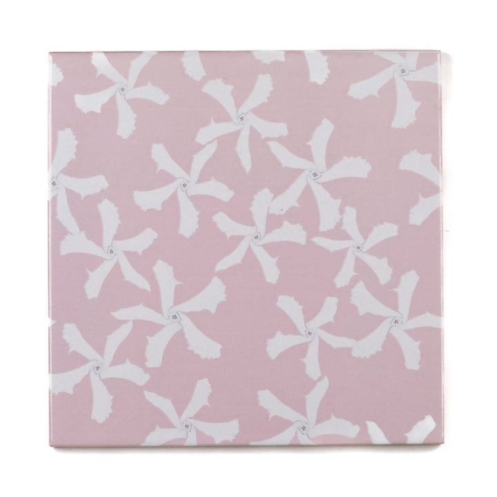 Pink ceramic tile with white floral pattern on a pink background