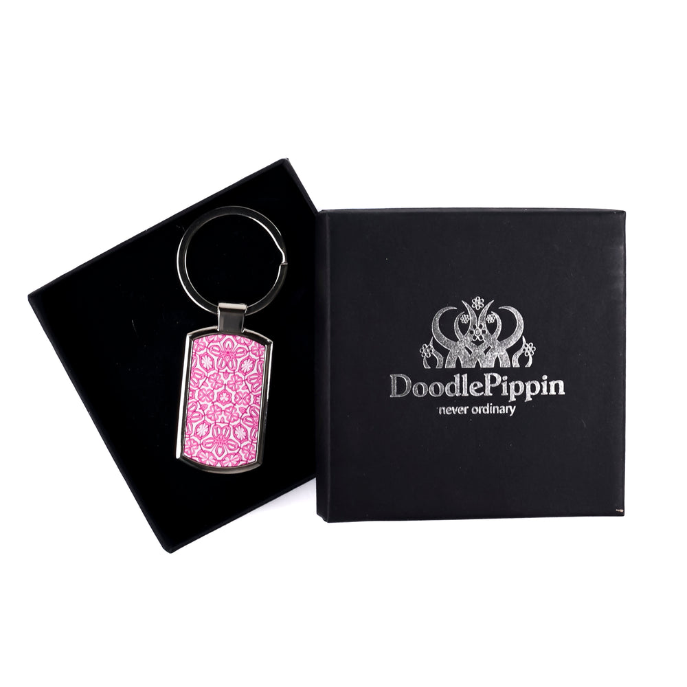 A metal keyring with a pink millefiori print design, presented in a silver-embossed black DoodlePippin box with velvet liner.