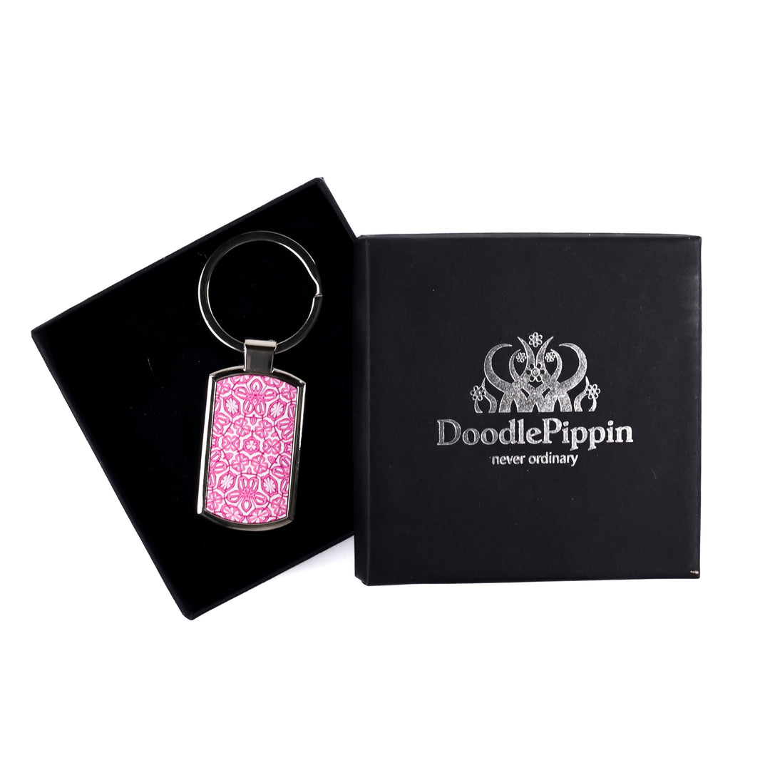 A metal keyring with a pink millefiori print design, presented in a silver-embossed black DoodlePippin box with velvet liner.